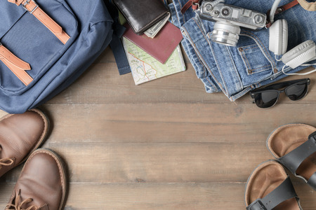 prepare backpack accessories and travel items on wood background with copy space, flat lay, top view...
