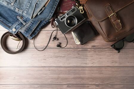 Accessories for travel plan, trip vacation, tourism - vintage leather bag and old jeans on wood...