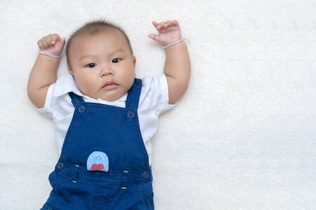 Cute asian baby lying on wool and looking at camera, Health care concept..の写真素材