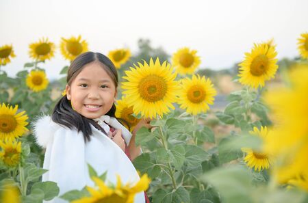 Happy cute asian girl smile with sunflower, travel and relaxation concept.の写真素材