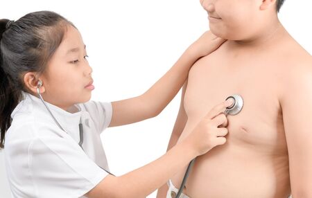 Little doctor check heart by stethoscope to obese asian boy isolated on white background, healthcare concept.の写真素材