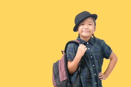 Cute little girl wearing hat smiling and holding backpack to travel summer trip in holiday on...
