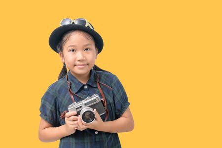 Cute little asian girl  sunglasses and holding vintage camera  on yellow background, Travel concept and copy spaceの写真素材
