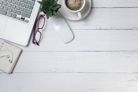 White wood desk table with laptop computer and coffee  on white wood
