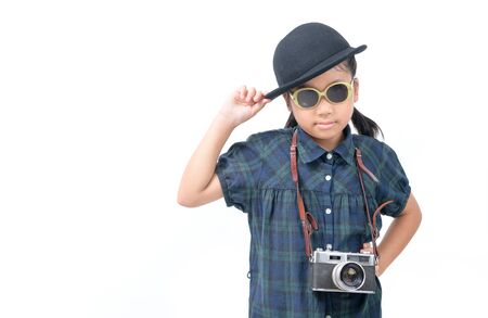 Cute little asian girl wear sunglasses with vintage camera isolated on white background, Travel concept and copy spaceの写真素材