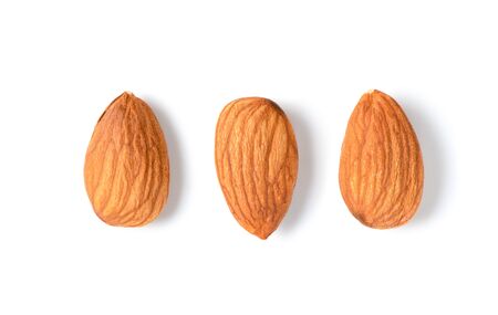 Three peeled almonds isolated on white background. Almonds are very popular nuts and high protein . healthy food.の写真素材