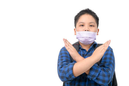 Wrong way to wear surgical mask, Schoolboy wearing a surgical mask in the wrong way isolated on white background, prevent covid-19 infection conceptの写真素材