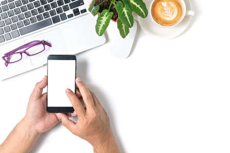 Hand  man touch on white screen smartphone with laptop and coffee isolated on white background, top...