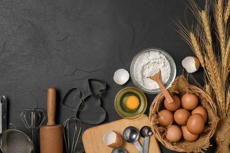 fresh eggs and cake flour  with kitchen utensils for pastries on black table, prepare for make cake...