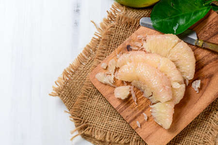 fresh peeled Pomelo or grapefruit on  wood plate. Seasonal fruit of Thailand, pomelo or citrus...