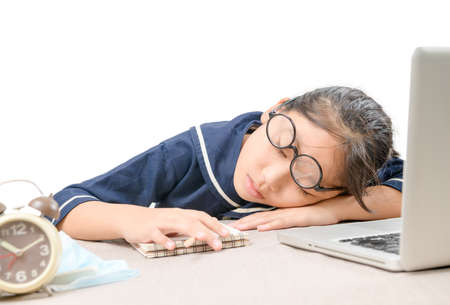 Tried student fell asleep while doing homework with the laptop isolated on white background, education conceptの写真素材