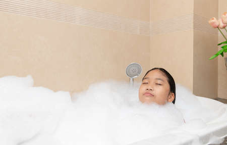 Bathing little girl relaxing in bath smiling relaxing. Caucasian child woman in bathtub. relax time...