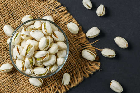 pistachios in glass cup on black table background , Top view. Healthy nuts conceptの写真素材