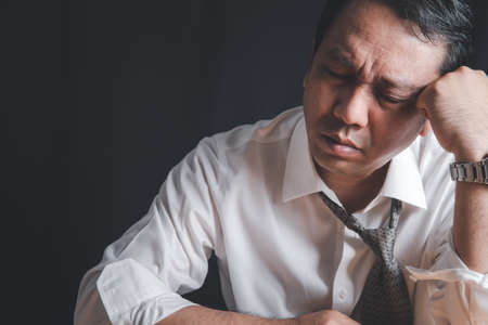 Businessman feel headache and stressed from hard work due to poor economic conditions in 2021 as a result of the covid-19 outbreak.の写真素材