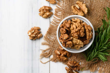 Top view of Walnut in white cup on wood background. healthy nuts concept. Walnuts are an excellent source of antioxidants and including LDL cholesterol, which promotes atherosclerosis.の写真素材