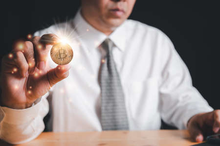 Businessman hold Golden Bitcoinの写真素材