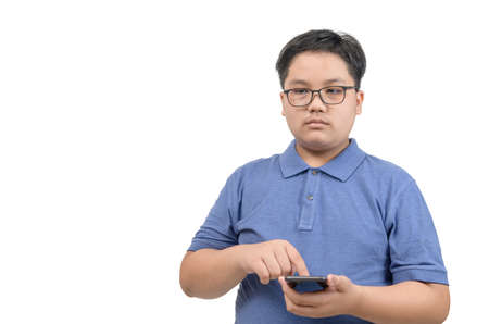 Boy wear eye glasses and touch on screen mobile phone isolated on white background, kids addicted to mobile phone games conceptの写真素材
