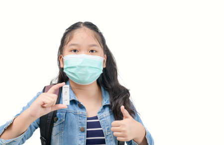 cute traveler wear mask shows rapid Coronavirus Covid-19 negative test device with negative test result isolated on white background, new normal travel conceptの写真素材