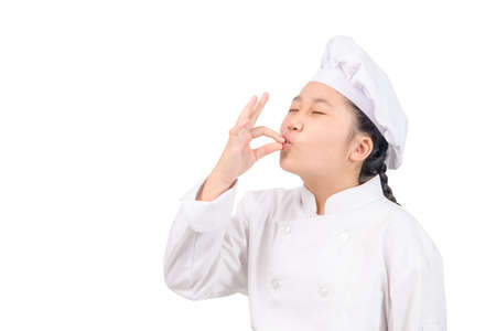 Cute chef girl showing sign for delicious. Kid chef in white uniform with perfect sign. Serious satisfied bearded chef, cook or baker gesturing excellent. Cook with taste approval gesture.の写真素材