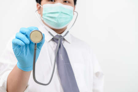 Young doctor holding stethoscope on white background. Asian male model , Concept Cosmetic Surgeryの写真素材