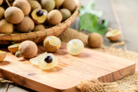 Fresh longan fruits on wood plate and old wood background, Asia fruit
