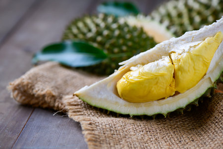 Puangmanee durian on wood plate and wood background, It's a small durian. very Delicious, sweet, creamy and so tasty. king of fruit in Thailandの写真素材