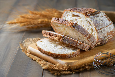 Sliced Sourdough Bread on wood board on wood background, homemade bakery concept