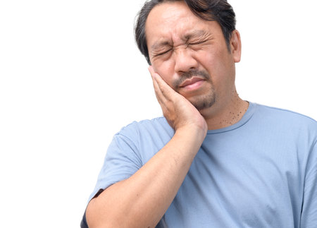 Handsome middle age senior man wearing blue shirt isolated background touching mouth with hand with painful expression because of toothache or dental illness on teeth. Dentist concept.の写真素材