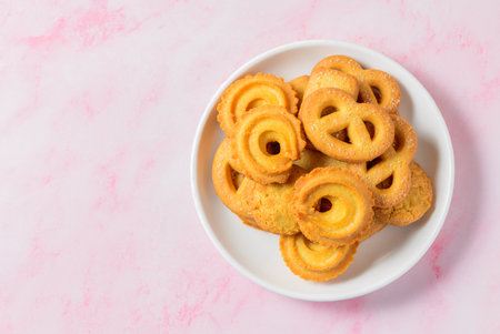 Set of danish butter cookies macro cutout. Five whole pretzel, round and rectangular shortbread biscuits with sugar on pink background. Danish pastry and sweet food concept. Top view.の写真素材