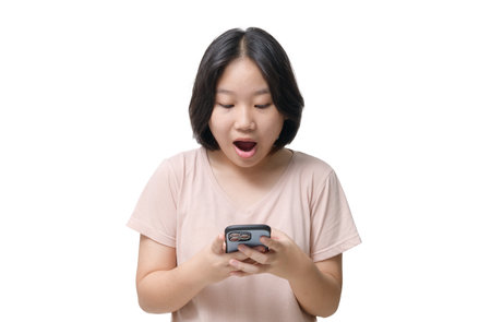 Portrait of attractive cheerful amazed asian girl using device gadget app isolated over white  background. emotion conceptの写真素材