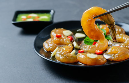 Pickled shrimp with chopstick Soy Sauce, chilli and garlic on stone background, korean foodの写真素材