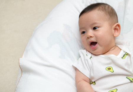 cute cheerful baby smile in bed. Happy emotion infant conceptの写真素材