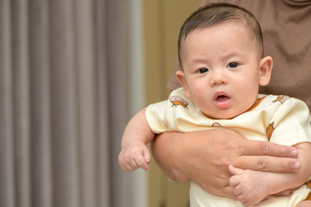 cute cheerful baby smile in father hand. emotion infant concept