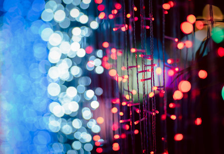 Abstract colorful bokeh orbs on dark background, vibrant defocused light dots pattern, festive overlay texture for photo editing, blurred bright circular shapes for creative graphic design backdropの写真素材