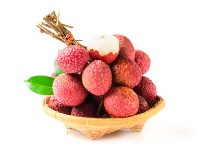 Juicy Lychee with cut in half and leaves on bamboo basket isolated on white background. Thai fruits conceptの写真素材