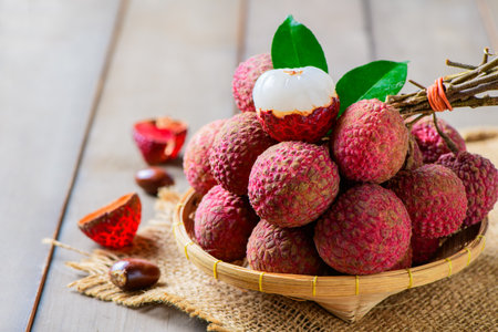 Juicy Fresh Lychee in Bamboo Basket on Rustic Wooden Table â Tropical Exotic Fruit or summer themed content.の写真素材