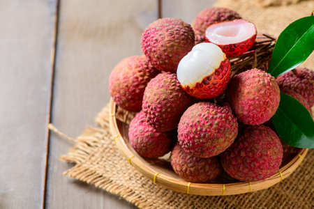 tyop view of Juicy Fresh Lychee in Bamboo Basket on Rustic Wooden Tableの写真素材