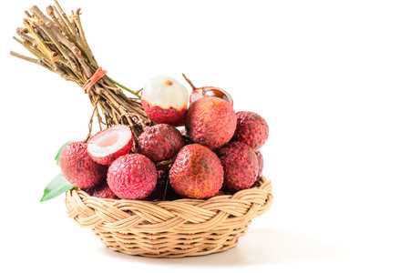 Juicy Lychee with cut in half and leaves on bamboo basket isolated on white background. Thai fruits conceptの写真素材