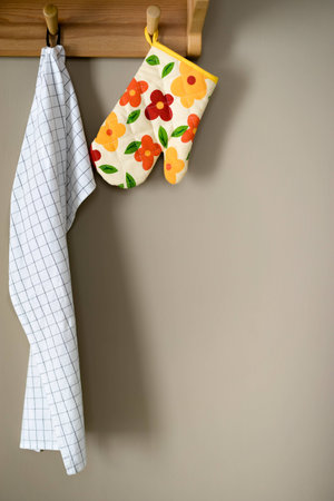 Napkin and gloves hanging on wood with brown kitchen wall.の写真素材