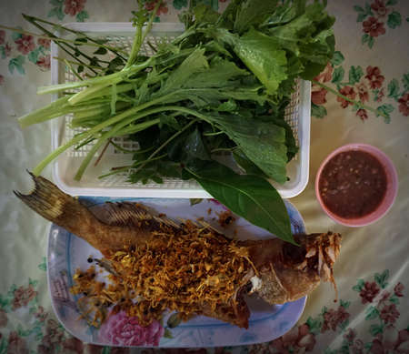 Fried whole sea bass with mixed herbs and chillies