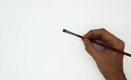 hand holding a brush drawing on a white background