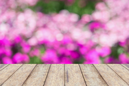 wood floor with pink flowers garden blurred backgroundの写真素材