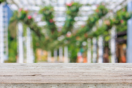 wood table with flowers hanging garden blurred backgroundの写真素材