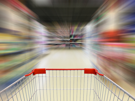 supermarket shopping cart view with supermarket aisle motion blurの写真素材