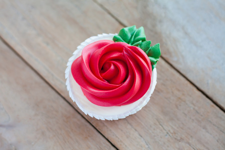red rose cupcake on wooden tableの写真素材