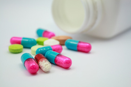 Colored pills, tablets and capsules on white backgroundの写真素材