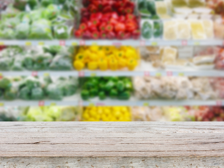Empty wood table top on Vegetables shelf in supermarket blurred backgroundの写真素材