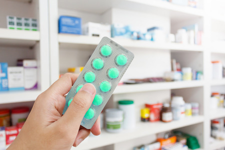 pharmacist hand hold medicine pills in the pharmacyの写真素材