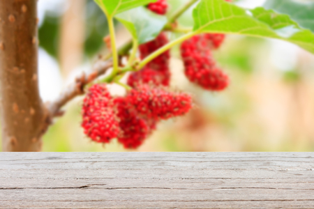 wood table with red mulberries background, product displayの写真素材
