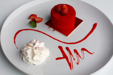 sweet strawberry cake with whipped cream on white plateの写真素材